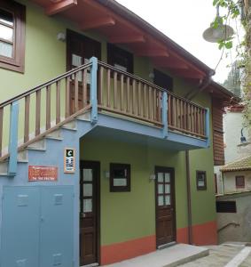a house with a balcony and a blue garage at Villa Cudillero - recep H Isabel in Cudillero