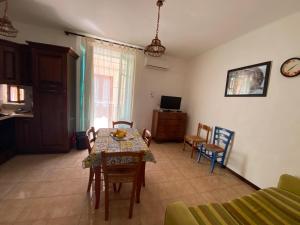 un soggiorno con tavolo, sedie e TV di Lipari Centro Storico Flat 7 mins from port a Città di Lipari