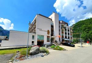 a hotel building with a mountain in the background at Das Hotel Sherlock Holmes in Meiringen