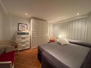 1 dormitorio con 1 cama, armario y TV en Sicilian Seaside Apartments, en Augusta