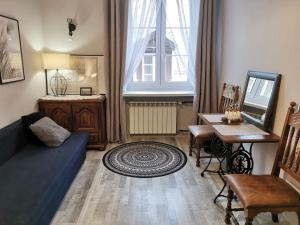 a living room with a blue couch and a table at Cozy room in the Old Town in Warsaw