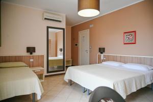 a hotel room with two beds and a mirror at Stella del Sud in Avola