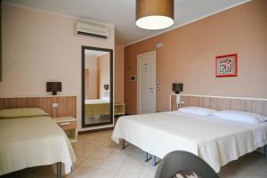 アヴォラにあるStella del Sudのベッド2台と鏡が備わるホテルルームです。