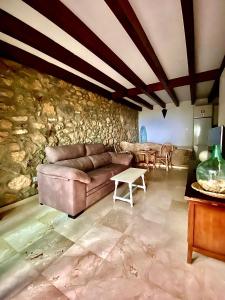 sala de estar con sofá y pared de piedra en Punta Paloma en Tarifa