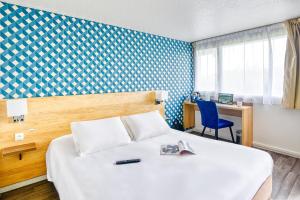 Habitación de hotel con cama y escritorio en Kyriad Montauban Sud - Albasud en Montauban
