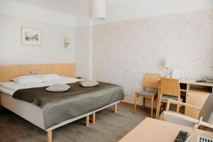 1 dormitorio con 1 cama, mesa y sillas en Hotel Tartu, en Tartu