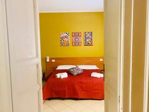 um quarto com uma cama com um cobertor vermelho em Angelo Apartments & Rooms em Trapani