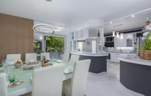 a kitchen with white cabinets and a table and chairs at Villa Palma Selina in Selina