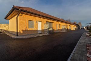 a yellow building with a road in front of it at Motel Atos Bungalovi in Nova Topola