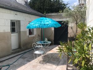 une table et deux chaises sous un parasol dans l'établissement LA PETITE COUR, à Loches