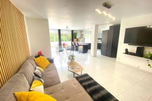 勒博塞VILLA 6 PERSONNES /PISCINE/CAMPAGNE/TERRAIN DE PETANQUE/15 km BANDOL的客厅里有一张沙发和一台电视