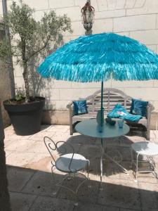 una mesa con una sombrilla azul en el patio en LA PETITE COUR, en Loches 3 fotos más