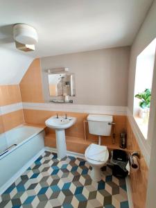 a bathroom with a toilet and a sink and a tub at The Swan Hotel in Hythe