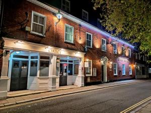 a brick building on a street at night at The Swan Hotel in Hythe