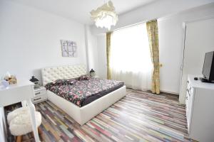 a bedroom with a bed and a tv and a window at FLH - Mountain View Apartment in Sibiu