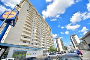 a parking lot with cars parked in front of a building at FLH - Mountain View Apartment in Sibiu