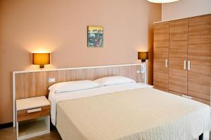 ein Schlafzimmer mit einem großen weißen Bett und zwei Lampen in der Unterkunft Stella del Sud in Avola