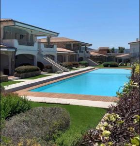 a swimming pool in front of a house at Sardinia Gold Luxury Apartment in Palau