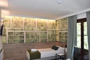 バルセロナにあるCasp Green Houseのベッド1台とガラスの壁が備わる客室です。