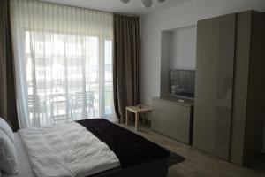 a bedroom with a bed and a tv and a window at De Silva Residence in Mamaia