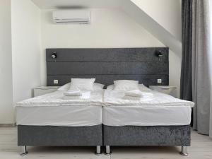 a bed with a black headboard in a bedroom at Q-Panzió in Tata