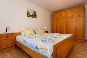 ein Schlafzimmer mit einem großen Bett und einem Holzschrank in der Unterkunft Apartment Mira Šilo-Krk in Šilo