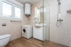 ein Badezimmer mit Waschmaschine und Waschbecken in der Unterkunft Apartment Mira Šilo-Krk in Šilo