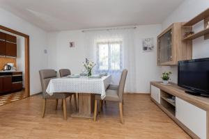 eine Küche und ein Esszimmer mit Tisch und Stühlen in der Unterkunft Apartment Mira Šilo-Krk in Šilo