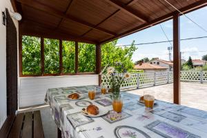einen Tisch mit Speisen und Getränken auf der Veranda in der Unterkunft Apartment Mira Šilo-Krk in Šilo
