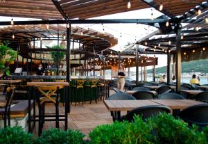 a restaurant with tables and chairs and people in the background at Kerman Hotel in Cesme