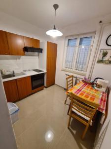 a kitchen with a table and chairs in a room at Apartments Ana in Medulin