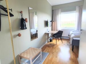 Cette chambre comprend un lit, une table et un miroir. dans l'établissement Bommersvik Hotell & Konferens, à Järna