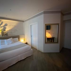 une chambre avec un grand lit blanc et un miroir dans l'établissement Picinque B, à Côme