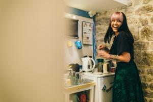 a woman is standing in a kitchen at Fiesta Siesta Social Hostel in Split