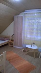 ザラカロシュにあるÁgnes Villaのテーブルとベッド、窓が備わる客室です。
