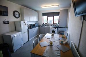 cocina con mesa y cocina con nevera en St Hilda Guesthouse, en Liverpool