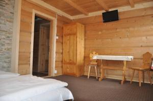 a bedroom with a bed and a desk in a room at Gościniec u Groszka in Bukowina Tatrzańska