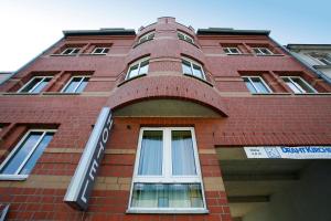 Un edificio alto de ladrillo rojo con una ventana redonda. en Hotel Regina - Bed & Breakfast Köln, en Colonia 18 fotos más