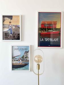 three posters hanging on a wall in a room at Bleu Soleil Rochefort 3 étoiles in Rochefort