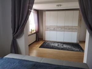 a bedroom with white cabinets and a bed and a window at Ferienwohnung Sahi in Celle