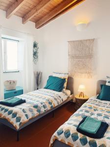 1 dormitorio con 2 camas y ventana en Casa da Vila, en Odeceixe