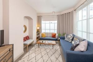 a living room with two blue couches and a tv at Monmouth Street Bath in Bath