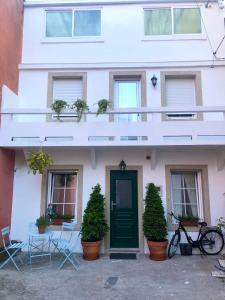 un edificio blanco con una puerta verde y plantas en Casa Casco Antiguo A Guarda, en A Guarda