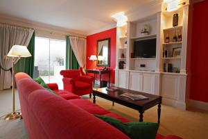 a living room with red walls and a red couch at The Yeatman in Vila Nova de Gaia