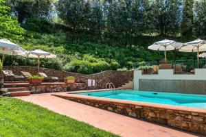 a swimming pool with umbrellas in a yard at Il Torrino Country Resort in Montaione