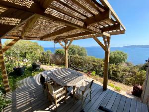 une terrasse en bois avec une table et des chaises. dans l'établissement T2 standing 800m de la plage de St Clair, au Lavandou