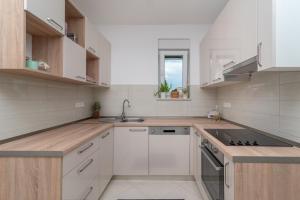 a white kitchen with a sink and a stove at Modern apt w terrace 2 min walk to the beach in Trogir