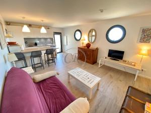 un soggiorno con divano viola e una cucina di T2 standing 800m de la plage de St Clair a Le Lavandou