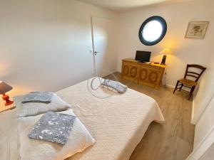 2 Betten in einem Zimmer mit einem Tisch und einem Spiegel in der Unterkunft T2 standing 800m de la plage de St Clair in Le Lavandou