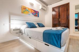 a bedroom with a large bed with blue pillows at Casa Vacanze Raggio di Luna in Villasimius